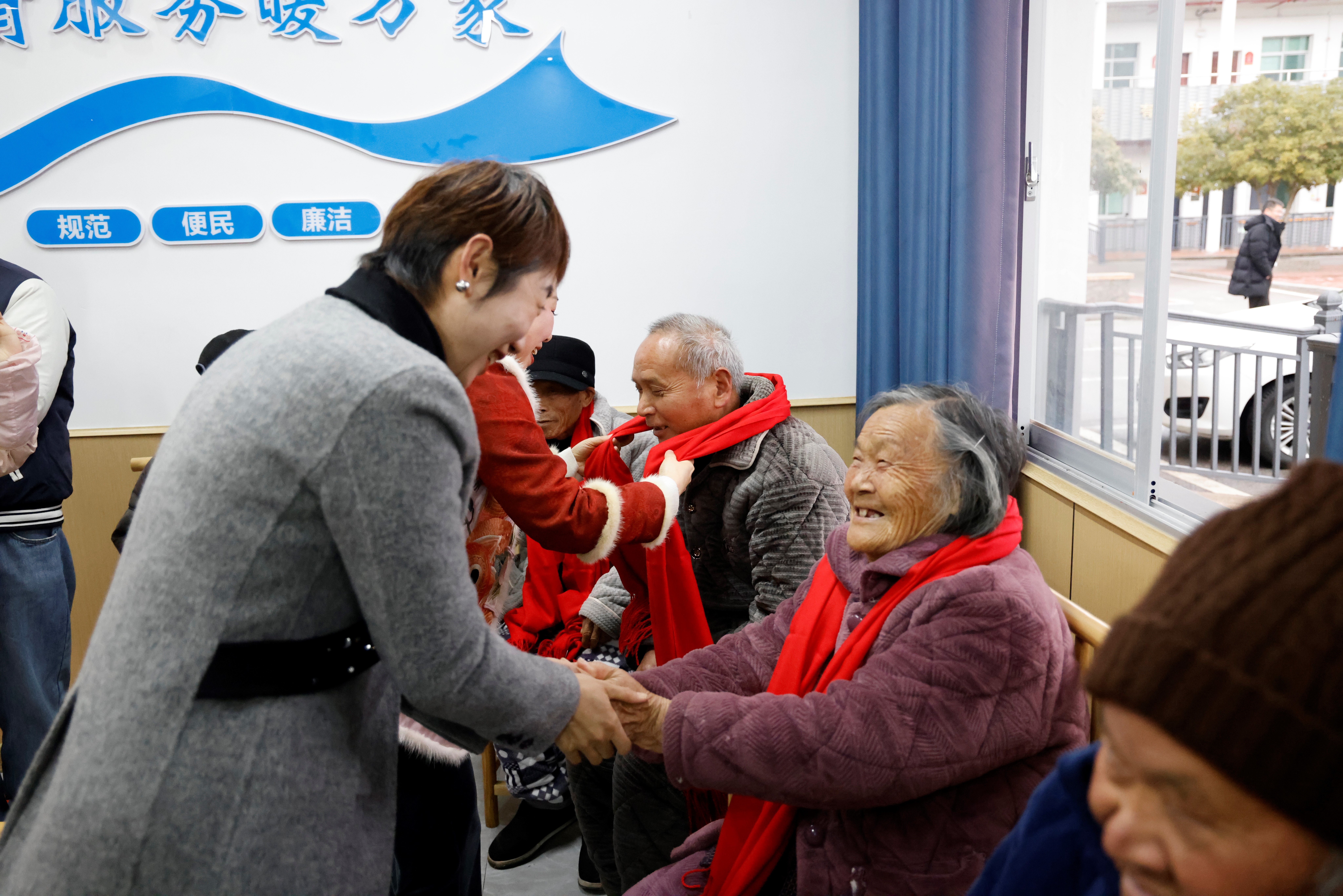 昌江区民政局工作人员给老人送红围巾。（本报全媒体记者 陈璋）.jpg