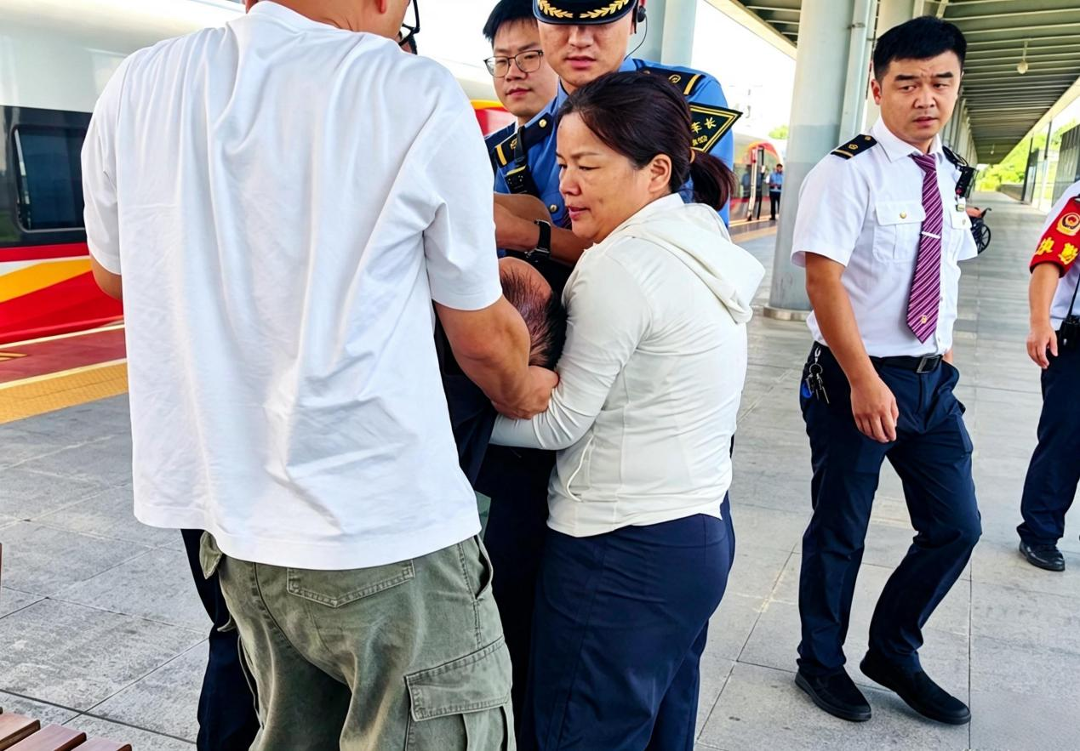 刘新娟与爱心人士一道,将患病旅客抬下列车施救。.png